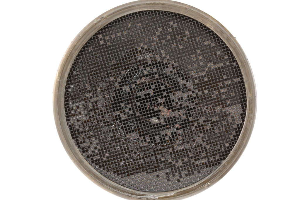 engine oil pickup tube screen with sludge and deposits close-up