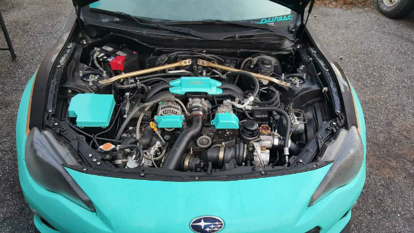 Car in shop with hood up for engine maintenance 